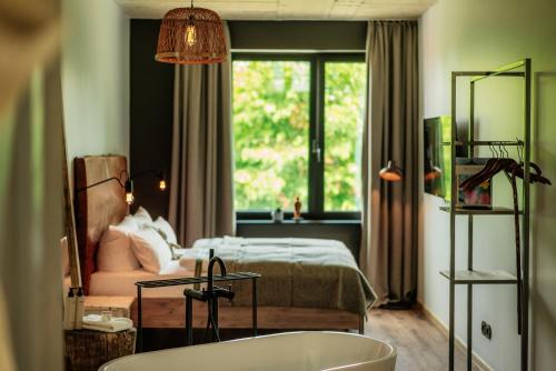 uma casa de banho com uma cama e uma banheira num quarto em THE HEARTS HOTEL - dein Boutique- und Event-Resort em Braunlage