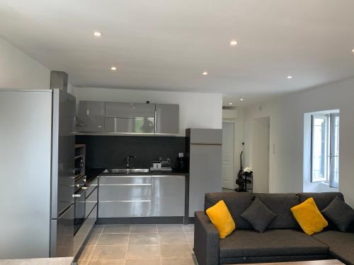 un salon avec un canapé et une cuisine dans l'établissement Au cœur de sartene, à Sartène