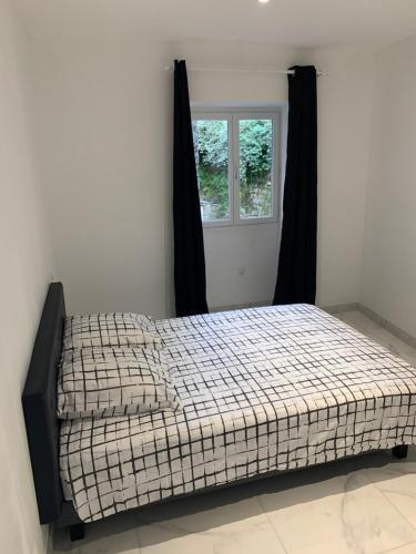 a bed in a room with a window at Au cœur de sartene in Sartène