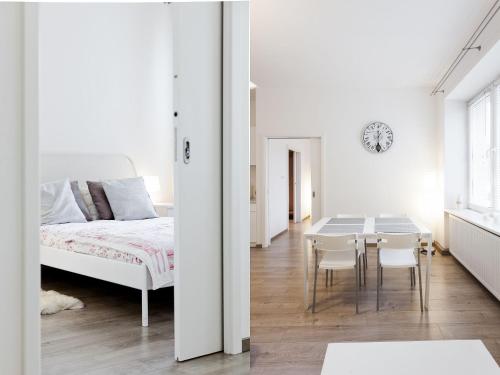 een slaapkamer met een bed en een tafel en stoelen bij Snow White Apartment in Krakau