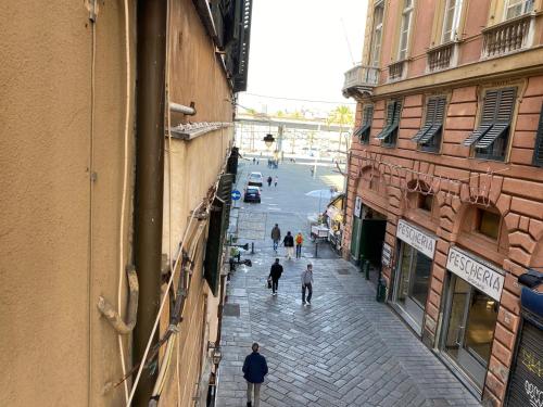 a group of people walking down a street between buildings at Appartamento al Ponte Reale in Genoa