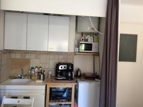 une petite cuisine avec un évier et un micro-ondes dans l'établissement studio cavalaire/mer proche de ST tropez, à Cavalaire-sur-Mer