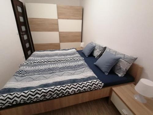 Schlafzimmer mit einem Bett mit blauer Bettwäsche und Kissen in der Unterkunft Tincha in Piran