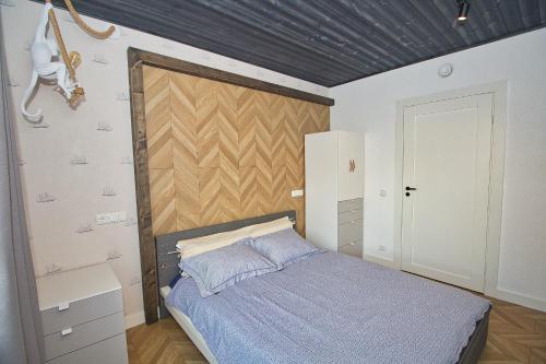 a bedroom with a bed with a wooden headboard at Casa Monkey Pärnu with sauna and terrace in Pärnu