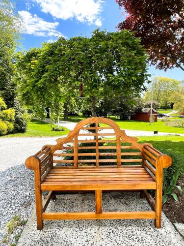 a wooden bench sitting on a sidewalk in a park at The Homestead in Madison