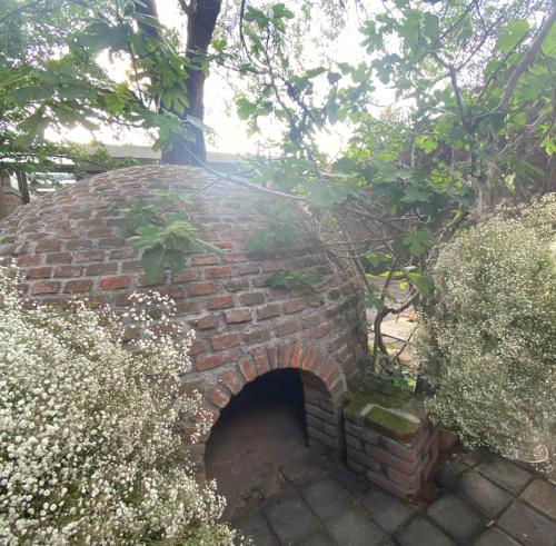 a brick oven in the middle of a garden at Posada Colibri - Hotel & Spa in San Juan Teotihuacán