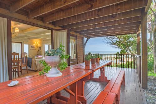 a wooden deck with a table and benches at Windhoek on Sea in Eersterivierstrand