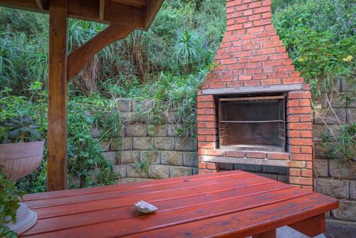 a brick oven sitting next to a wooden bench at Windhoek on Sea in Eersterivierstrand