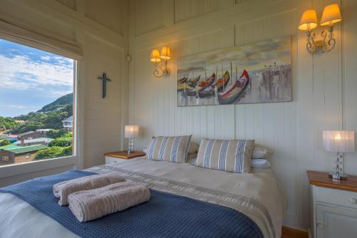 a bedroom with a bed with a cross on the wall at Windhoek on Sea in Eersterivierstrand
