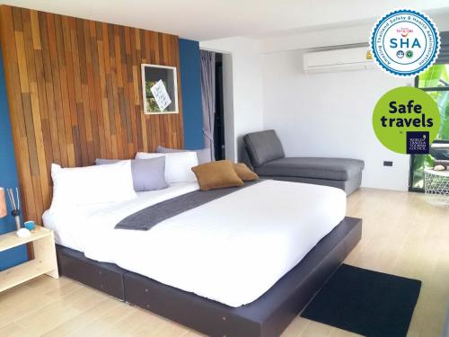 a large white bed in a room with a chair at Ao Luek Panoramic Pool-SHA Plus in Ao Luk