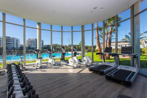 an indoor gym with cardio equipment and a swimming pool at Greenhills La Zenia luxe penthouse 5 pers Orihuela in Los Dolses