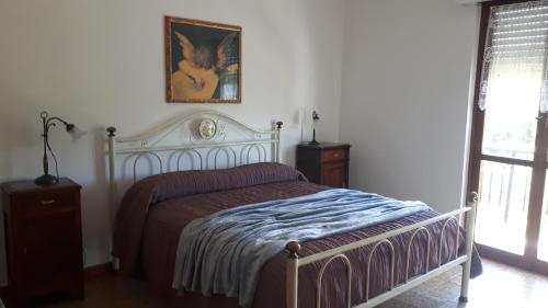 - une chambre avec un lit et une photo sur le mur dans l'établissement La casa della nonna, à Vara Superiore