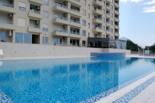 a large swimming pool in front of a building at Status-M Apartments 187 in Becici