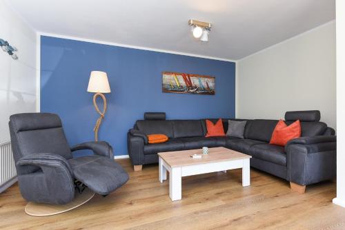 a living room with a couch and two chairs and a table at Ferienwohnungen Min Huus in Neuharlingersiel