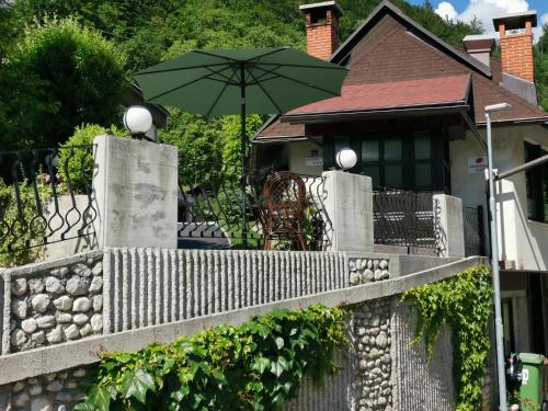 a fence with an umbrella in front of a house at Apartmaji Mak in Jesenice