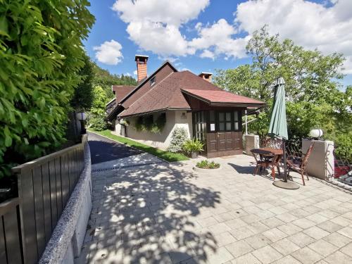 a house with a patio and an umbrella at Apartmaji Mak in Jesenice
