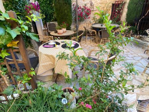 a patio with a table and chairs and plants at Hotel Le Saint Laurent in Saint-Laurent-des-Arbres