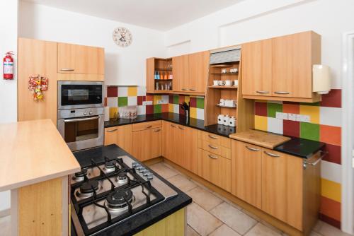 a kitchen with wooden cabinets and a stove top oven at Dene Hollow Oroklini in Voroklini