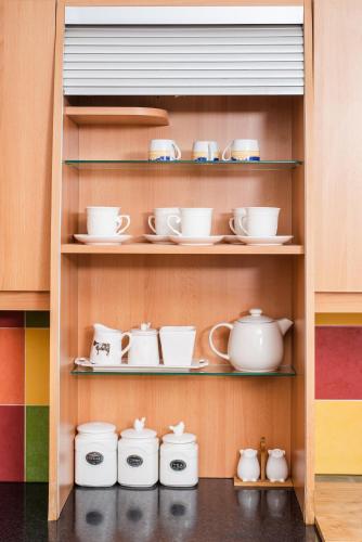 a shelf filled with cups and saucers at Dene Hollow Oroklini in Voroklini