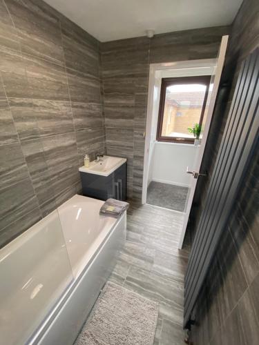 a bathroom with a tub and a toilet and a sink at Newly Refurbished Beautiful Location 1 Bedroom Residential House sleeps 4 in Cramlington