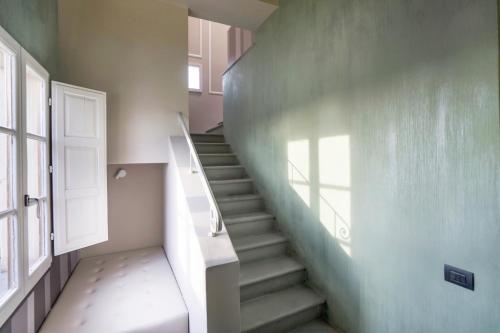 a staircase in a room with a door and a window at Palazzo dei Ciompi Suites in Florence