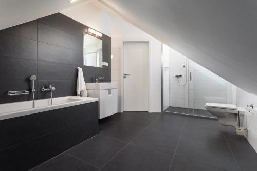 uma casa de banho com um lavatório, uma banheira e um WC. em Vila48 em Ostrava