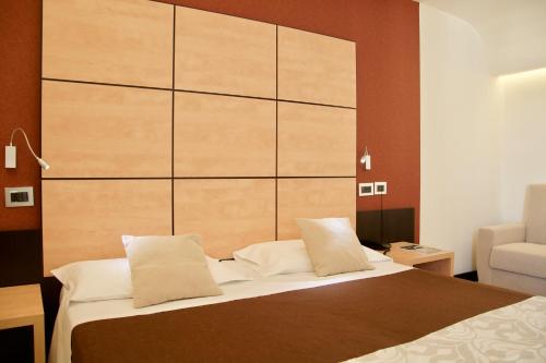 una camera con un letto con una grande testiera in legno di Hotel Cimarosa a Napoli