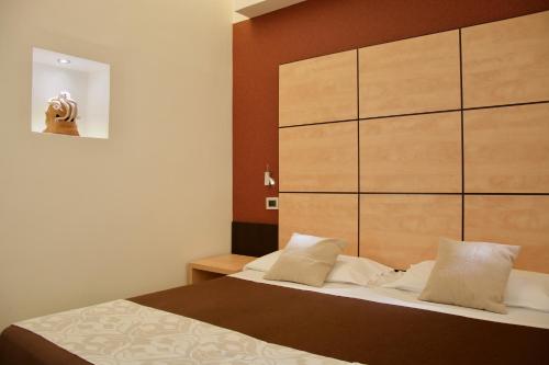 a bedroom with a bed with a large wooden headboard at Hotel Cimarosa in Naples