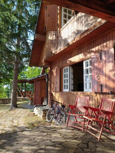 a group of red chairs sitting outside of a house at Chalet in legno in Campo di Giove