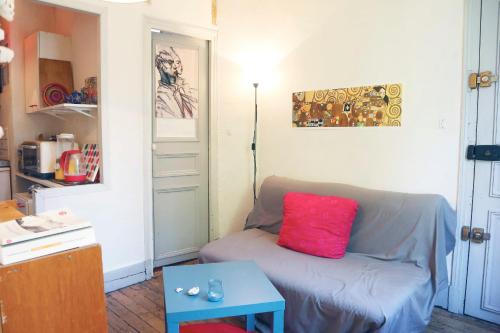un soggiorno con divano e cuscino rosso di Charming Bright Apartment Near Montmartre a Parigi