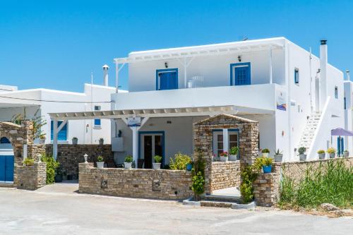 een wit huis met blauwe deuren en ramen bij Eleftheria Studios in Antiparos Stad