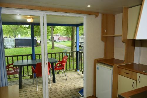a kitchen with a balcony with a table and chairs at Camping Noguera Pallaresa in Sort