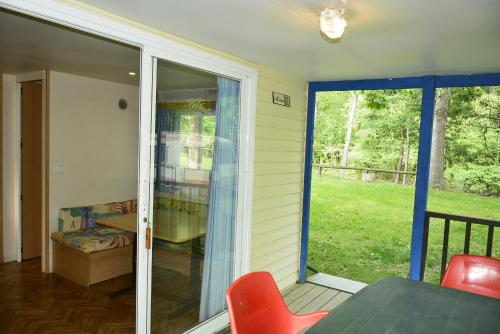 a screened in porch with a sliding glass door at Camping Noguera Pallaresa in Sort