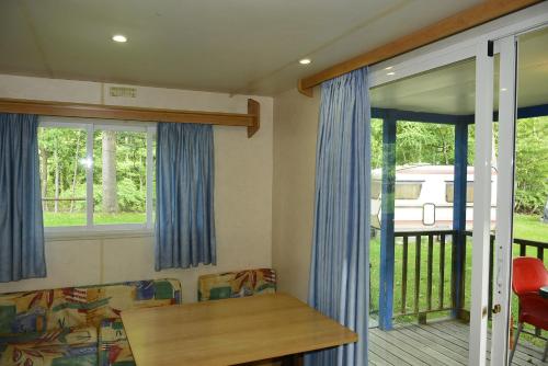 a living room with blue curtains and a couch at Camping Noguera Pallaresa in Sort