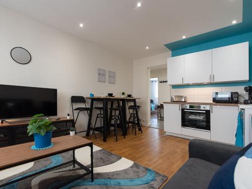 un salon avec un canapé et une table et une cuisine dans l'établissement LE VALLES - HYPERCENTRE PARKING GRATUIT WiFi NETFLIX AMAZON PRIME, à Villeurbanne