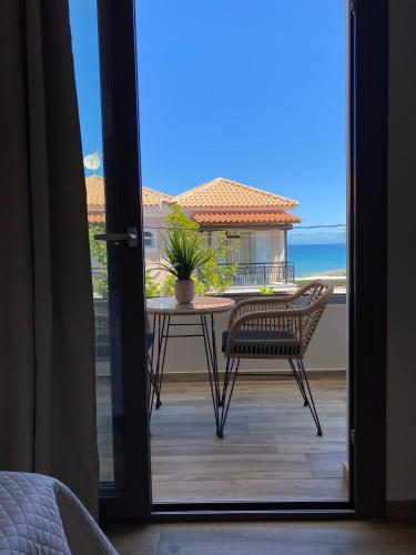 a balcony with a table and chairs and the ocean at Roula Kotsonis Superior Apartment in Argasi