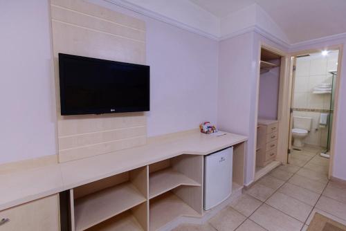 a white room with a tv on a wall at Fênix Hotel Moema in Sao Paulo