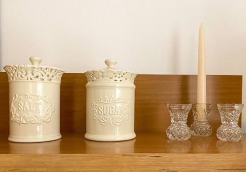 three white vases sitting on a shelf with glasses at Villa Adria in Vodice