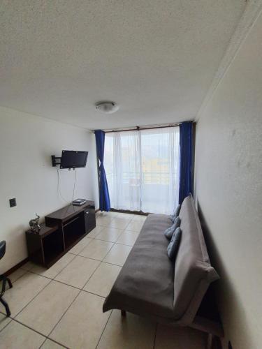 a living room with a couch and a large window at departamento NEO vista al mar 2 piezas in Iquique