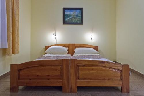 Una cama de madera en una habitación con 2 almohadas. en Babie Lato, en Okuninka
