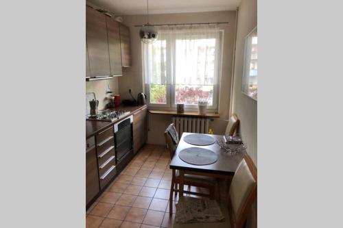 cocina con mesa, sillas y ventana en Apartament Siewna-moje miejsce na idealne wakacje, en Cracovia
