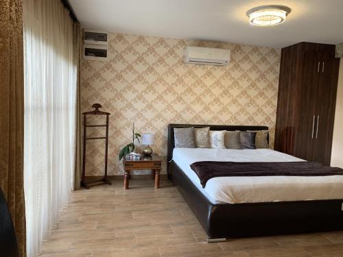 a bedroom with a large bed and a table at Villa Garden in Zalaegerszeg