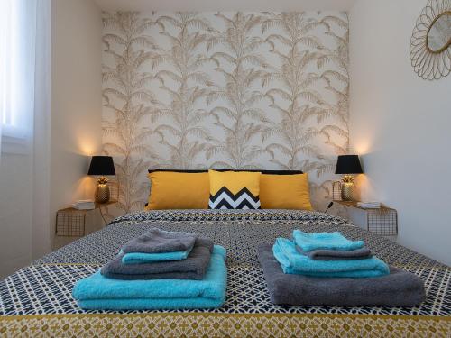 une chambre avec un lit avec des serviettes bleues dessus dans l'établissement LE VALLES - HYPERCENTRE PARKING GRATUIT WiFi NETFLIX AMAZON PRIME, à Villeurbanne