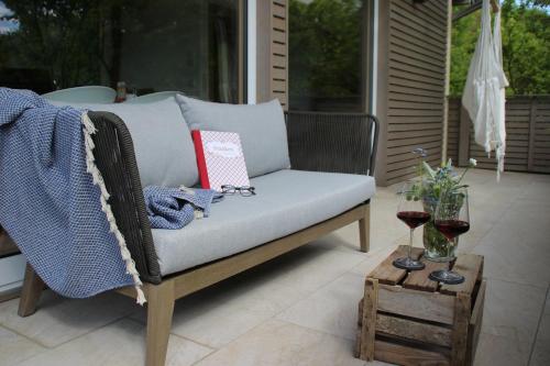 a chair sitting on a patio with a glass of wine at Ferienwohnungen Hasenknuck in Michelau