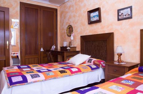 a bedroom with two beds and a table with a lamp at Tranquilidad en helguera in Helguera