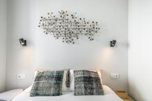 una lámpara de araña colgada sobre una cama con 2 almohadas en Bairro House Lisbon Charming Suites, en Lisboa