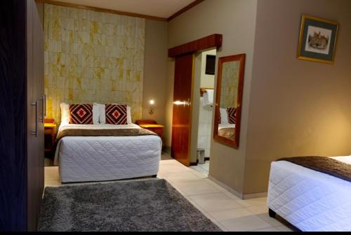 a bedroom with two beds and a hallway at Bloem Spa Hotel & Conference in Bloemfontein