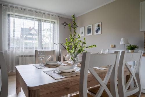 a dining room table and chairs with a white table and a table and chairsktop at Apartament Konda in Białka Tatrzańska