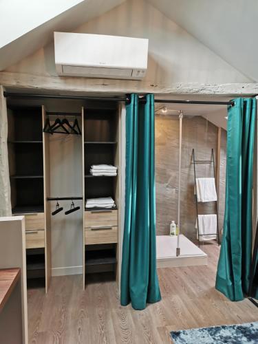 Cette chambre comprend une mezzanine dotée de rideaux bleus. dans l'établissement La Maison Saint Louis, à Cholet