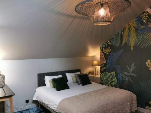 - une chambre avec un lit blanc et des oreillers verts dans l'établissement La Maison Saint Louis, à Cholet